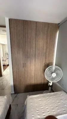 a bedroom with a bed and a wooden cabinet at Norte de Barranquilla in Barranquilla