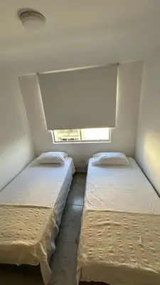 two beds in a small room with a window at Norte de Barranquilla in Barranquilla