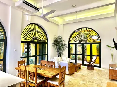 a dining room with large windows and a table and chairs at by Calamari Homes - El Porvenir 206 walled city in Cartagena de Indias