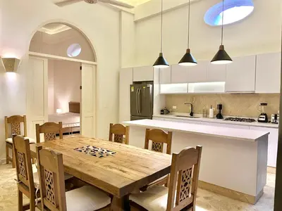 an open kitchen with a wooden table and chairs at by Calamari Homes - El Porvenir 206 walled city in Cartagena de Indias