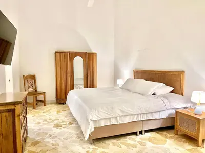 a bedroom with a large white bed and a table at by Calamari Homes - El Porvenir 206 walled city in Cartagena de Indias
