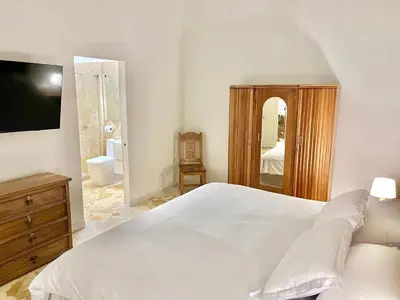 a bedroom with a large white bed and a mirror at by Calamari Homes - El Porvenir 206 walled city in Cartagena de Indias
