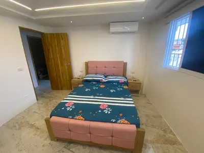 a bedroom with a bed and a pink couch at Casa de lujo en barrio popular in Cartagena de Indias