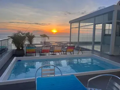 a swimming pool with a sunset in the background at HS-C Habitación Cuádruple con aire acondicionado y piscina in Cartagena de Indias