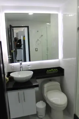 a bathroom with a toilet and a sink and a mirror at Arriendos S.H. Nuevo Conquistador in Cartagena de Indias