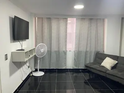 a living room with a couch and a flat screen tv at Apartamento en Bocagrande muy cerca al mar! Apto 401 in Cartagena de Indias