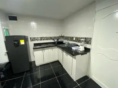 a small kitchen with white cabinets and a black refrigerator at Apartamento en Bocagrande muy cerca al mar! Apto 401 in Cartagena de Indias