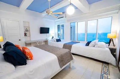 a bedroom with two beds with a view of the ocean at Renovated with ocean view in historic center! in Cartagena de Indias
