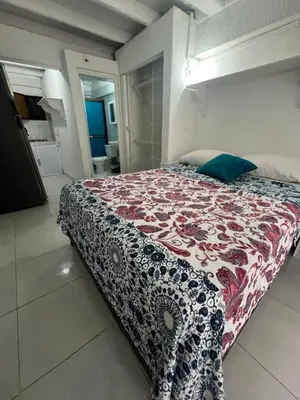 a bedroom with a bed with a red and white blanket at Apartaestudio Marbella in Cartagena de Indias