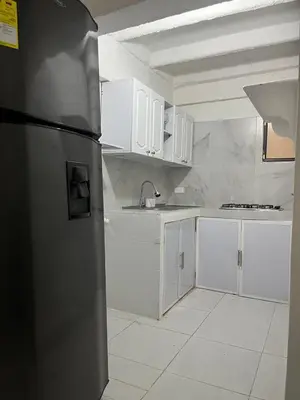 a kitchen with white cabinets and a stainless steel refrigerator at Apartaestudio Marbella in Cartagena de Indias