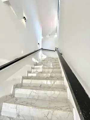 a staircase with white marble floors and white walls at Comfortable loft in Barranquilla in Barranquilla