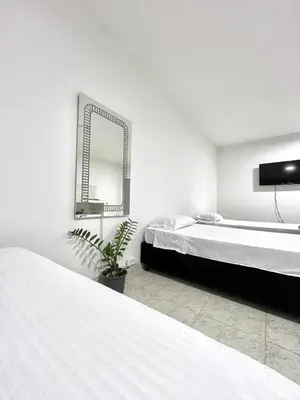 a bedroom with two beds and a mirror at Comfortable loft in Barranquilla in Barranquilla