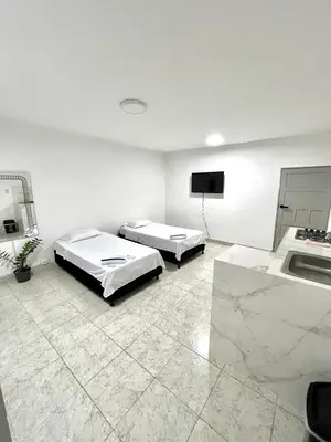 a large room with two beds and a tv at Comfortable loft in Barranquilla in Barranquilla