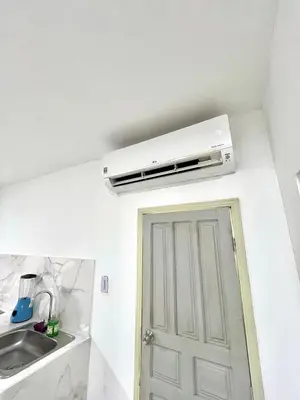 a white air conditioner on the wall above a kitchen door at Comfortable loft in Barranquilla in Barranquilla