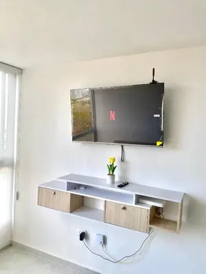 a tv hanging on a wall with a desk at Hermoso apartamento amoblado in Barranquilla