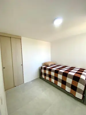 a room with a bed in the corner of a room at Hermoso apartamento amoblado in Barranquilla