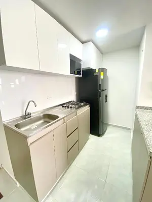 a kitchen with a sink and a black refrigerator at Hermoso apartamento amoblado in Barranquilla