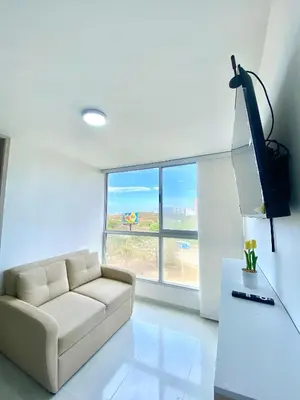 a living room with a couch and a large window at Hermoso apartamento amoblado in Barranquilla