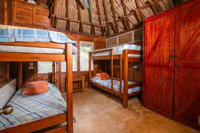 a room with three bunk beds in a cabin at Cabaña San Miguel in Moñitos