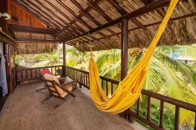 a hammock and a chair on a porch at Cabaña San Miguel in Moñitos
