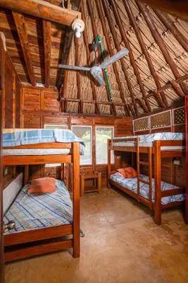 a room with three bunk beds in a cabin at Cabaña San Miguel in Moñitos
