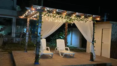 a gazebo with two chairs and lights at Habitacion con piscina-jacuzzi-lavadora disponible in Juan de Acosta