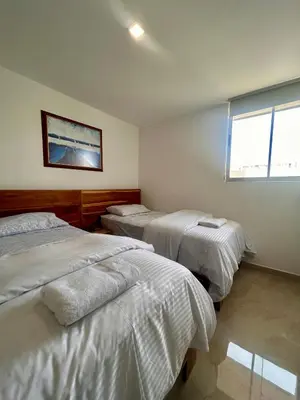 a bedroom with two beds and a window at Apto de lujo para estrenar in Barranquilla