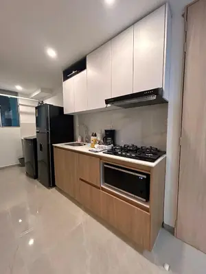 a kitchen with white cabinets and a stove and refrigerator at Apto de lujo para estrenar in Barranquilla