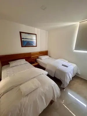 a bedroom with two beds and a picture on the wall at Apto de lujo para estrenar in Barranquilla