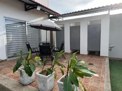 a patio with plants and an umbrella at Cabaña Don Jerónimo in Santa Veronica
