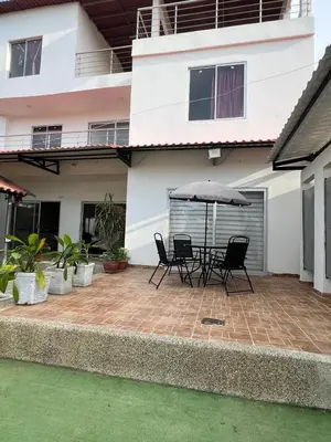 a patio with chairs and an umbrella in front of a house at Cabaña Don Jerónimo in Santa Veronica