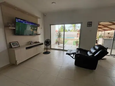a living room with a black leather chair and a flat screen tv at Cabaña Don Jerónimo in Santa Veronica