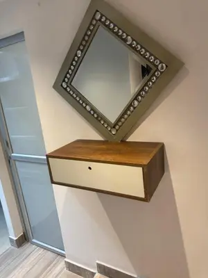 a mirror on a wall with a wooden shelf at Apartaestudio altos de riomar in Barranquilla