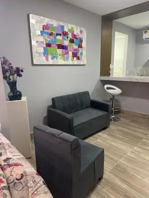 a living room with a couch and a mirror at Apartaestudio altos de riomar in Barranquilla