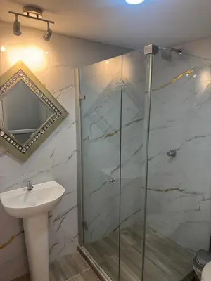 a bathroom with a glass shower and a sink at Apartaestudio altos de riomar in Barranquilla