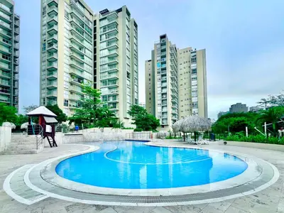 a large blue swimming pool with tall buildings in the background at Apartamento con vista al mar - Condominio Zazué in Santa Marta