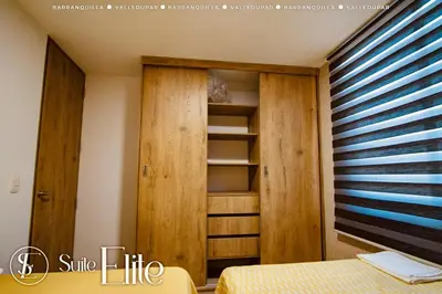a bedroom with wooden closets and a bed at Suite Elite Barranquilla in Barranquilla