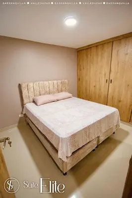 a bedroom with a bed and a wooden cabinet at Suite Elite Barranquilla in Barranquilla