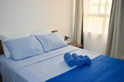 two blue mitts sitting on top of a bed at Comfortable apartment close to the beach 2 rooms in Cartagena de Indias