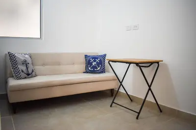 a bench with pillows on it next to a table at Comfortable apartment close to the beach 2 rooms in Cartagena de Indias