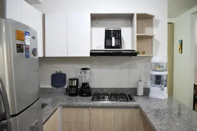 a kitchen with a stove and a refrigerator at Comfortable apartment close to the beach 2 rooms in Cartagena de Indias