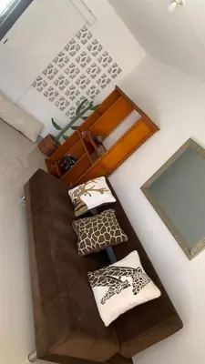 a room with a couch with pillows and a mirror at Apartamento Ciudad Jardin Barranquilla in Barranquilla