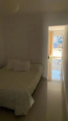a bedroom with a bed and a sliding glass door at Apartamento Ciudad Jardin Barranquilla in Barranquilla