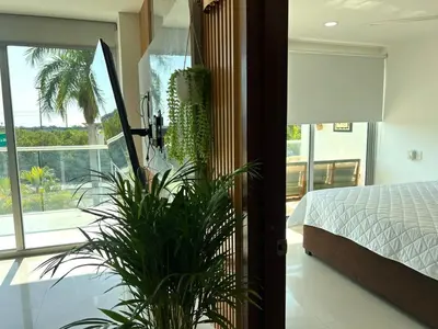 a bedroom with a bed and a plant next to a window at Luxury, Central y Exclusivo1 Linea Playa Privada in Cartagena de Indias
