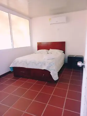 a bed in a room with a red tile floor at Dulce Barú in Cartagena de Indias
