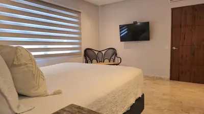 a bedroom with a bed and a flat screen tv at Spectacular Villa Near Walled City in Cartagena de Indias