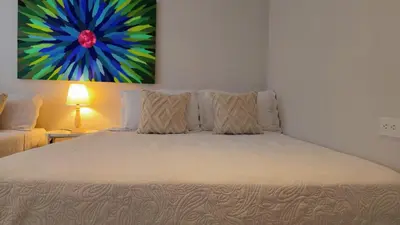 a bedroom with a bed with a painting on the wall at Spectacular Villa Near Walled City in Cartagena de Indias