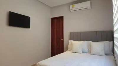 a bedroom with a bed with a television on the wall at Spectacular Villa Near Walled City in Cartagena de Indias
