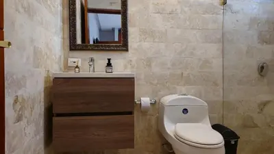a bathroom with a toilet and a sink and a mirror at Spectacular Villa Near Walled City in Cartagena de Indias