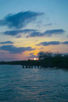 a sunset over a body of water with the sun setting at Villa Luz Coastal Sanctuary in Tintipan Island